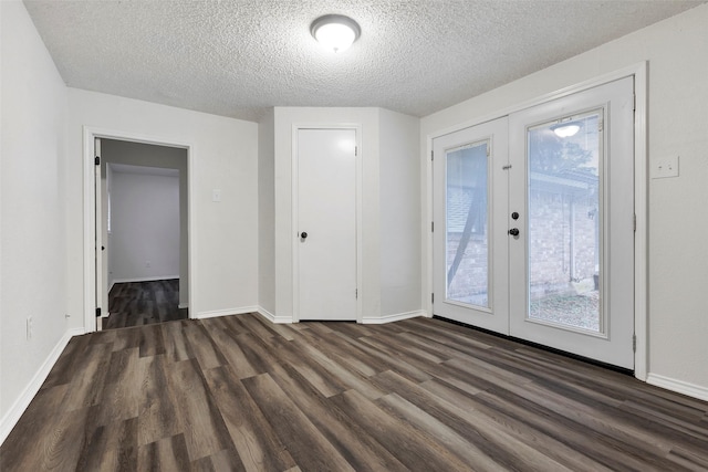 interior space featuring dark wood-type flooring, access to outside, a textured ceiling, and french doors