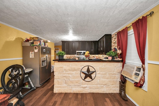 kitchen featuring a peninsula, dark countertops, stainless steel appliances, and dark wood-style flooring