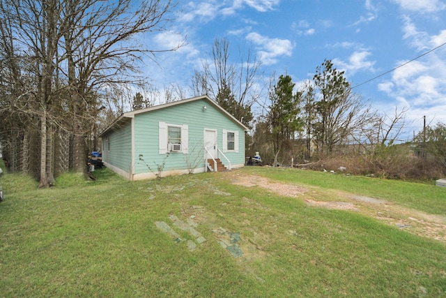 back of property featuring entry steps, cooling unit, and a yard