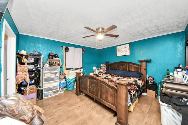 bedroom with a textured ceiling, a textured wall, a ceiling fan, light wood finished floors, and crown molding