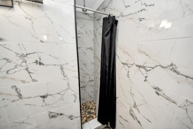 full bathroom with a marble finish shower