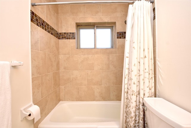 bathroom featuring shower / tub combo and toilet