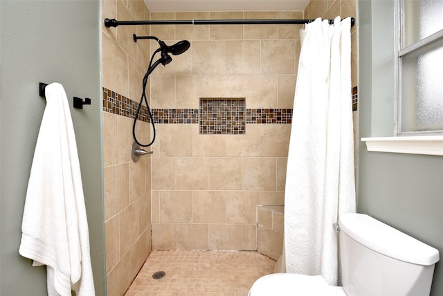 bathroom with a shower with shower curtain and toilet