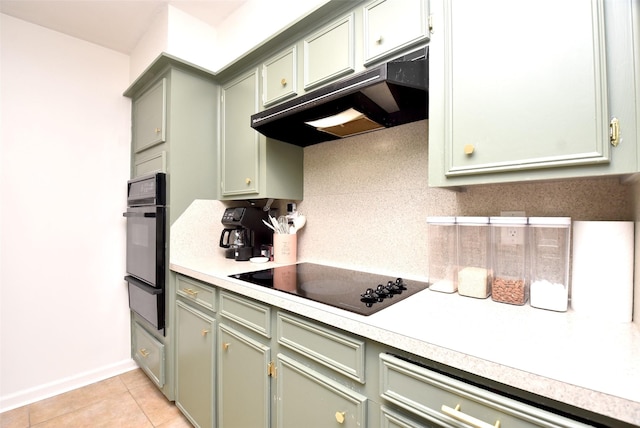 kitchen with backsplash, green cabinetry, light tile patterned floors, and black appliances