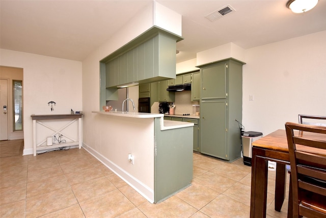 kitchen with light tile patterned flooring, refrigerator, green cabinetry, oven, and kitchen peninsula