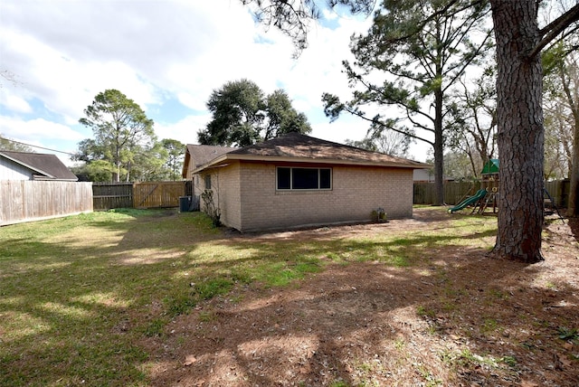 rear view of house featuring a playground and a yard