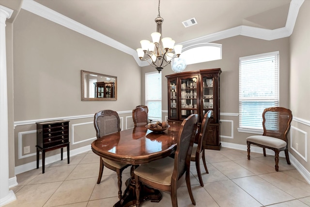 dining area featuring crown molding, a healthy amount of sunlight, lofted ceiling, and light tile patterned floors