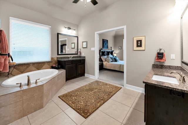 bathroom featuring tile patterned floors, vaulted ceiling, vanity, ceiling fan, and tiled bath