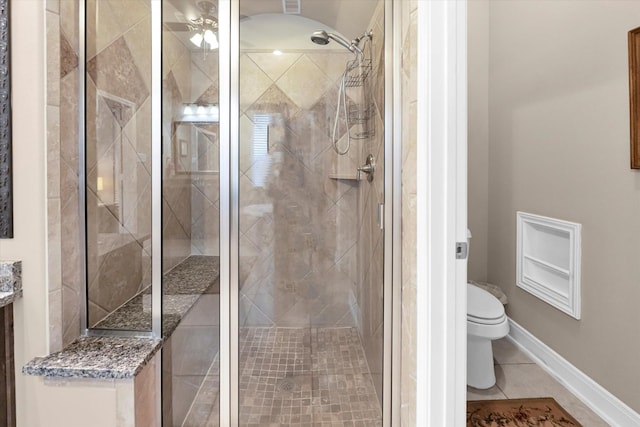 bathroom featuring tile patterned flooring, a shower with door, and toilet