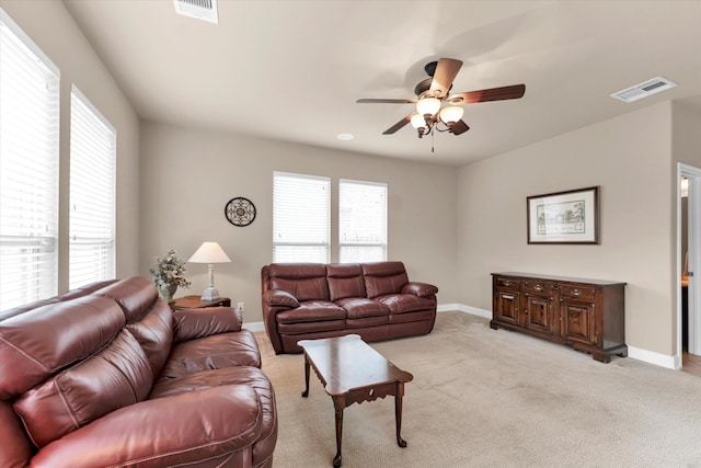 carpeted living room with ceiling fan