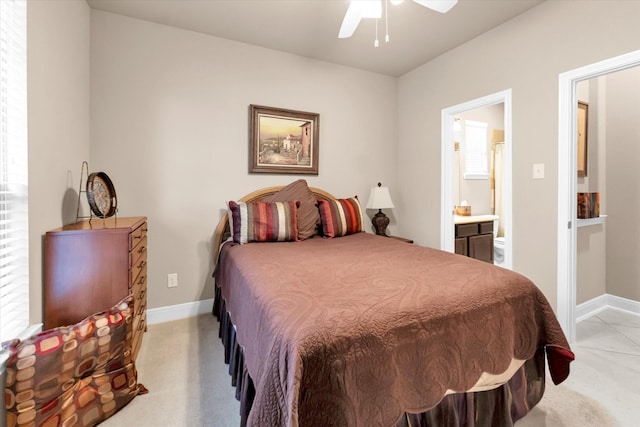 bedroom featuring ensuite bathroom, light colored carpet, and ceiling fan