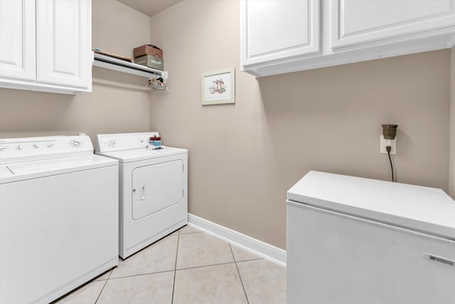 washroom with cabinets, washer and clothes dryer, and light tile patterned floors