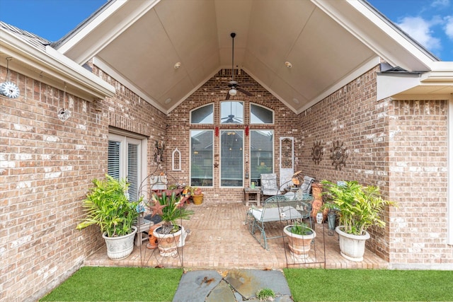 view of exterior entry with a patio area and ceiling fan