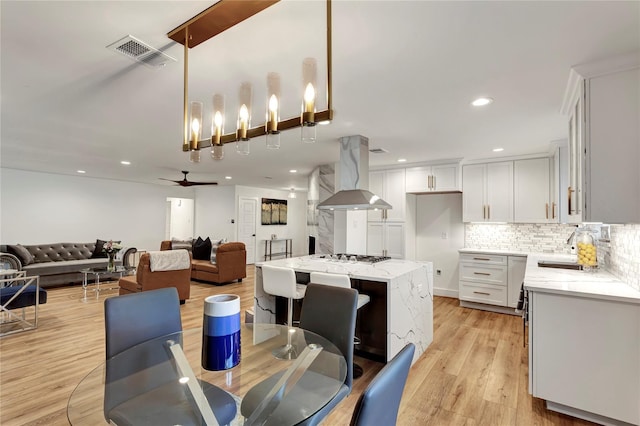 dining room featuring sink, light hardwood / wood-style floors, and ceiling fan