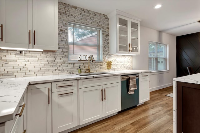 kitchen with white cabinetry, sink, light stone countertops, and dishwasher