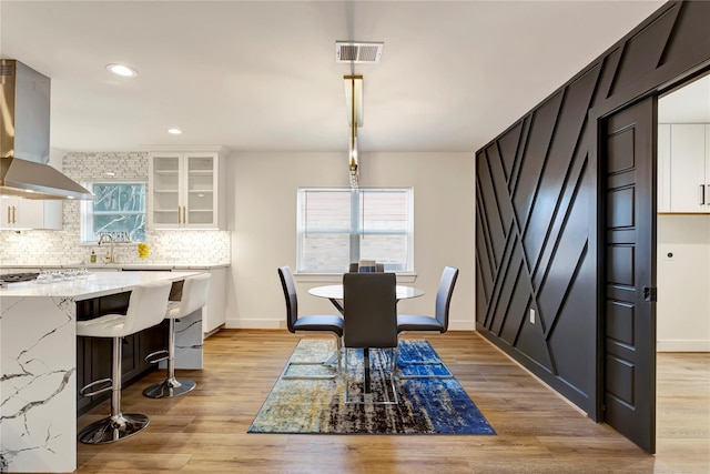 dining area featuring sink, a healthy amount of sunlight, and light wood-type flooring