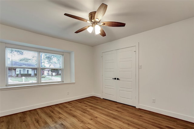 unfurnished bedroom featuring ceiling fan, a closet, and light hardwood / wood-style flooring