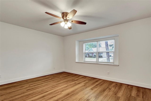 empty room with ceiling fan and light hardwood / wood-style flooring