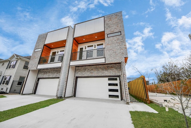 view of front of property featuring driveway, a balcony, a garage, and fence