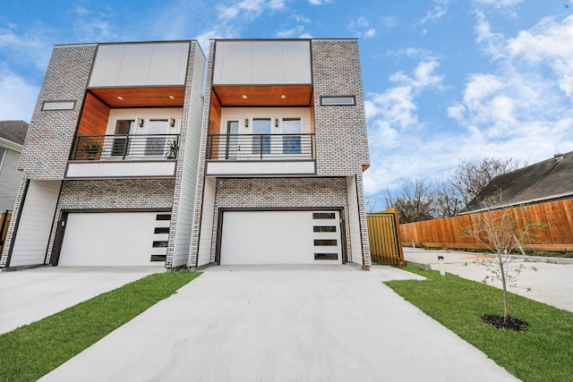 view of front of property with a balcony, an attached garage, fence, and concrete driveway