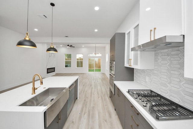 kitchen featuring light countertops, decorative light fixtures, and white cabinetry