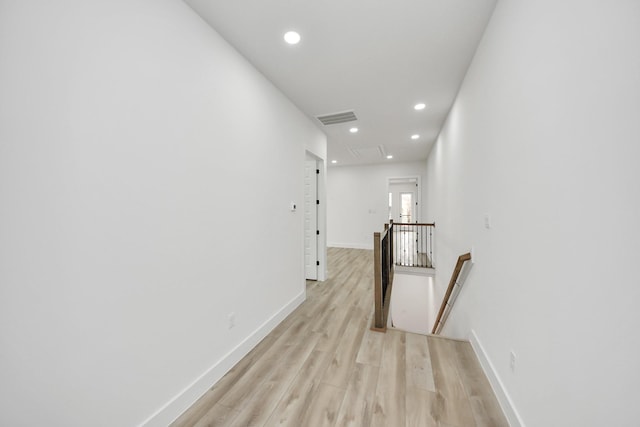 hallway with recessed lighting, light wood-style flooring, visible vents, and an upstairs landing