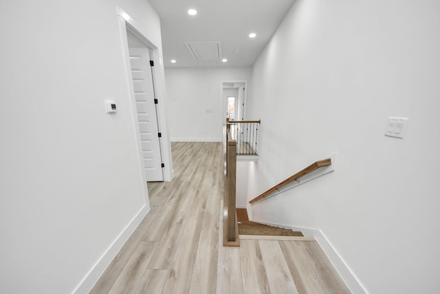 hallway featuring attic access, baseboards, an upstairs landing, light wood-type flooring, and recessed lighting