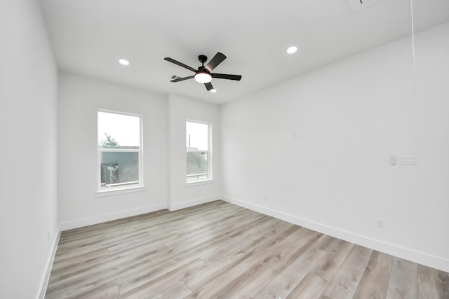 spare room featuring ceiling fan, light wood-style flooring, recessed lighting, baseboards, and attic access