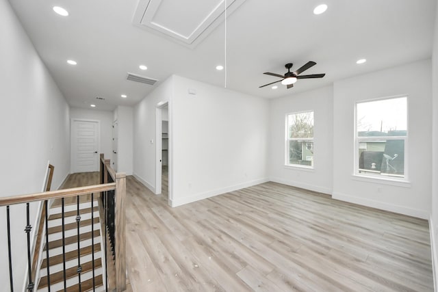 spare room with attic access, visible vents, baseboards, light wood-type flooring, and recessed lighting