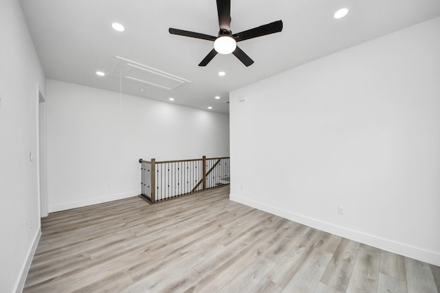 unfurnished room featuring light wood finished floors, attic access, baseboards, and recessed lighting