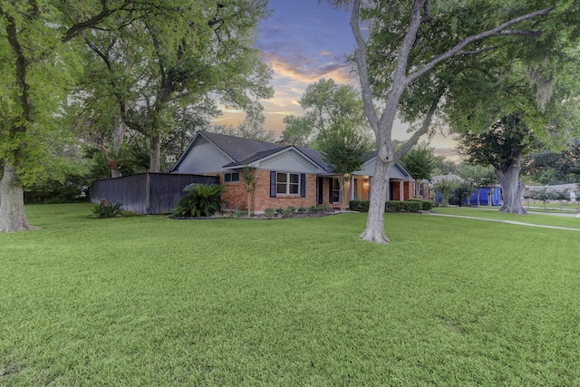 ranch-style home with a yard