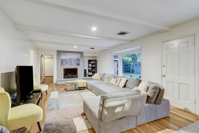 living room featuring beam ceiling and light wood-type flooring