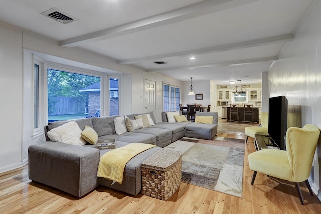 living room with beamed ceiling and light wood-type flooring