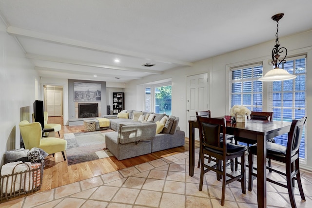 dining space featuring beamed ceiling and light wood-type flooring