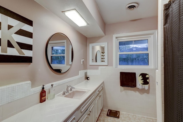 bathroom featuring tile walls, vanity, and a shower with shower curtain