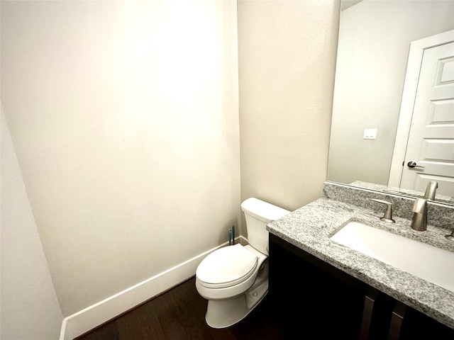 bathroom with hardwood / wood-style flooring, vanity, and toilet