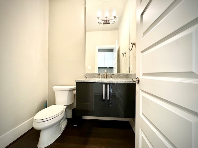 bathroom with vanity, wood-type flooring, and toilet