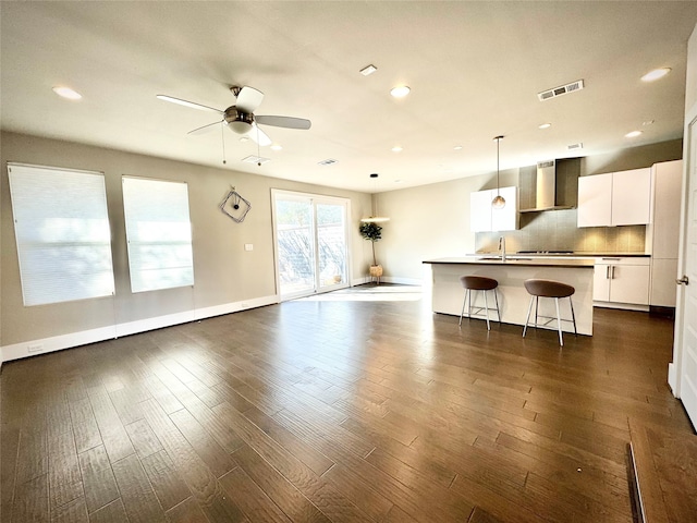 unfurnished living room with ceiling fan, dark hardwood / wood-style flooring, and sink