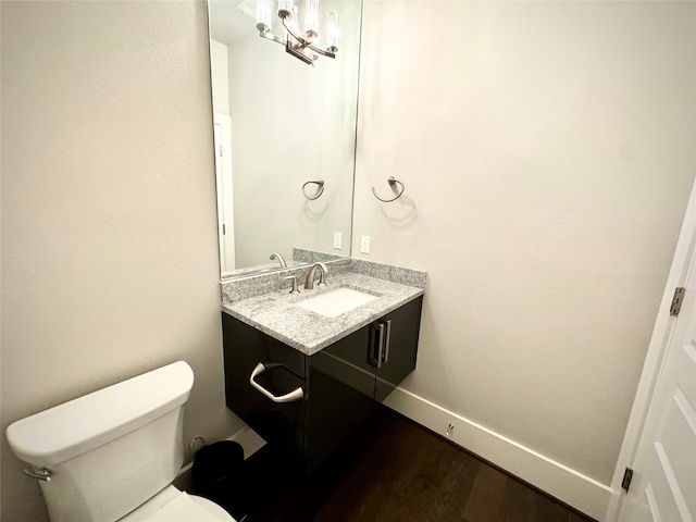 bathroom with vanity, toilet, and hardwood / wood-style floors