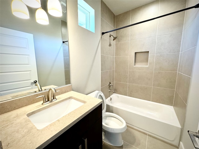 full bathroom featuring tiled shower / bath, vanity, and toilet