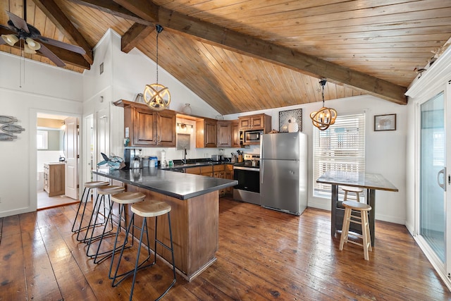 kitchen with decorative light fixtures, lofted ceiling with beams, a kitchen bar, dark hardwood / wood-style flooring, and stainless steel appliances