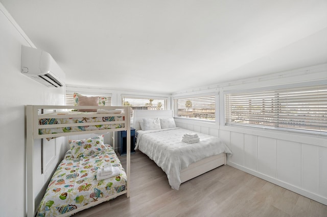 bedroom featuring light hardwood / wood-style flooring and an AC wall unit