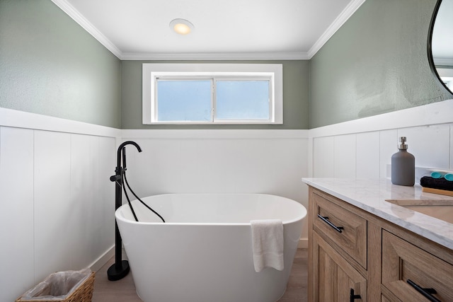 bathroom featuring ornamental molding, a washtub, and vanity