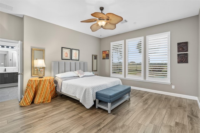 bedroom featuring light wood-type flooring, visible vents, connected bathroom, and baseboards