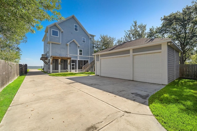 3418 Miramar Dr, Shoreacres, TX 77571 - rear view of house featuring a garage, an outdoor structure, a yard, and a sunroom