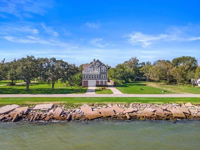 3418 Miramar Dr, Shoreacres, TX 77571 - rear view of house with a water view and a lawn