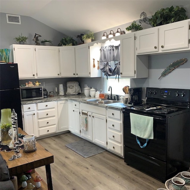 kitchen featuring white cabinetry, lofted ceiling, sink, and black appliances