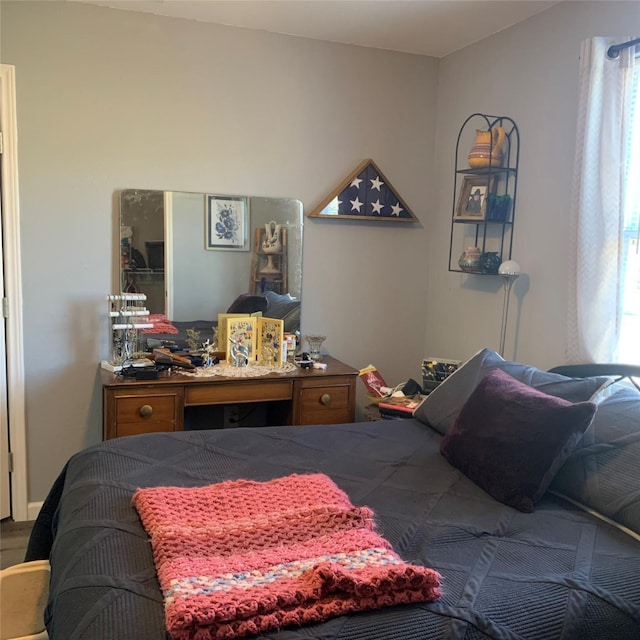 bedroom with multiple windows and hardwood / wood-style floors