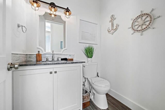 bathroom featuring vanity, wood-type flooring, and toilet