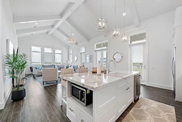 kitchen with white cabinetry, appliances with stainless steel finishes, sink, and a center island with sink